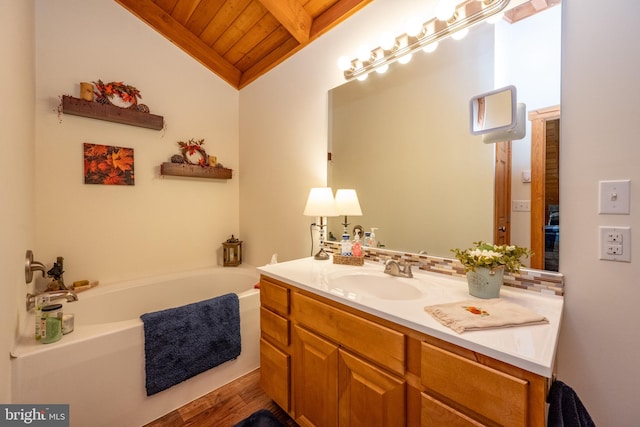 bathroom with hardwood / wood-style floors, vanity, vaulted ceiling, wood ceiling, and a bathtub