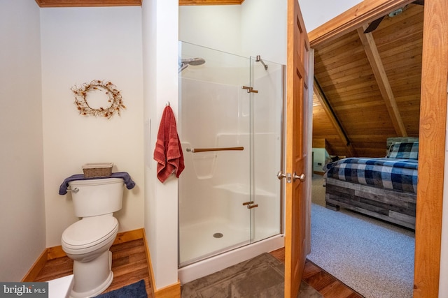 bathroom with toilet, ensuite bathroom, a shower stall, wood finished floors, and baseboards