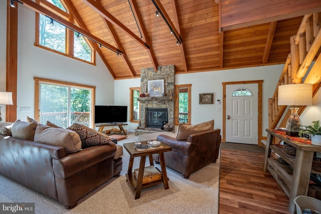 living area with wooden ceiling, a fireplace, wood finished floors, beam ceiling, and track lighting