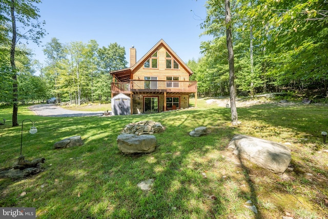 rear view of house featuring a yard, a chimney, and a wooden deck