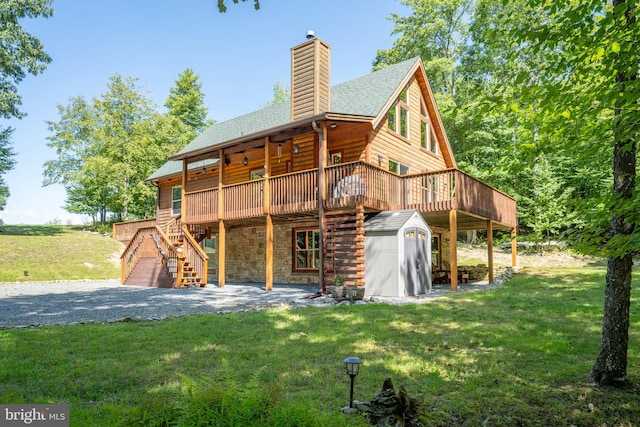 rear view of property with an outbuilding, a storage shed, stairway, a lawn, and a chimney