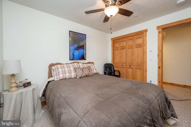 carpeted bedroom featuring a ceiling fan, a closet, and baseboards