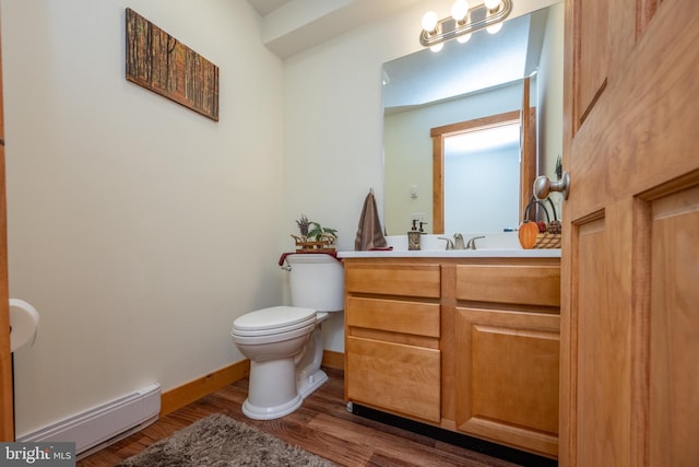 half bathroom featuring baseboards, toilet, wood finished floors, baseboard heating, and vanity