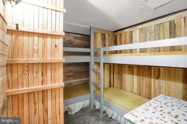 carpeted bedroom with wood walls