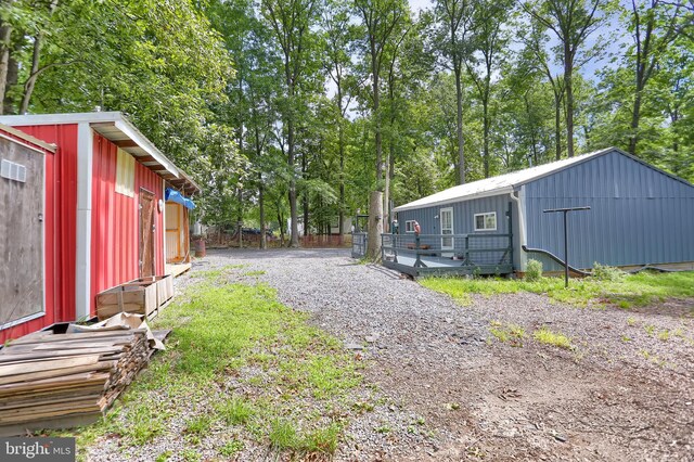 view of yard featuring a wooden deck and an outbuilding