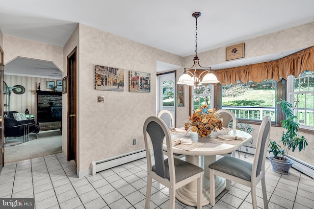 dining space featuring a baseboard heating unit, a fireplace, a chandelier, and light tile patterned floors