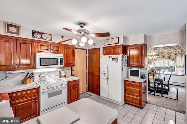 kitchen featuring white appliances, light colored carpet, a baseboard radiator, and ceiling fan