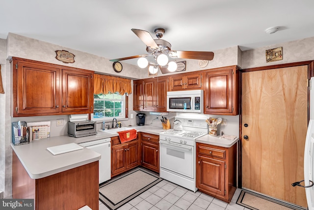 kitchen with light tile patterned floors, white appliances, sink, kitchen peninsula, and ceiling fan