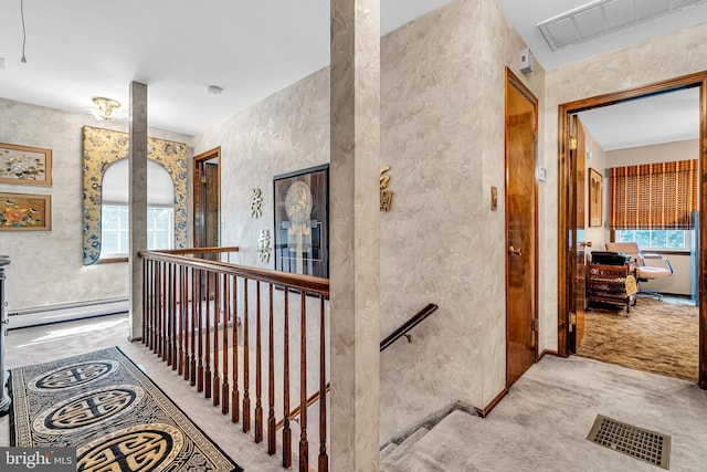 hallway with light colored carpet and baseboard heating