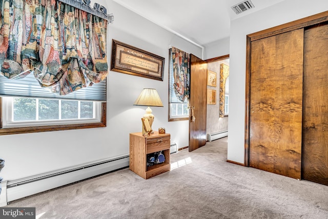 unfurnished bedroom featuring light colored carpet and a baseboard radiator