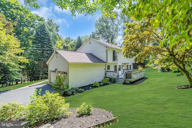 view of side of home featuring a yard, a garage, and a deck