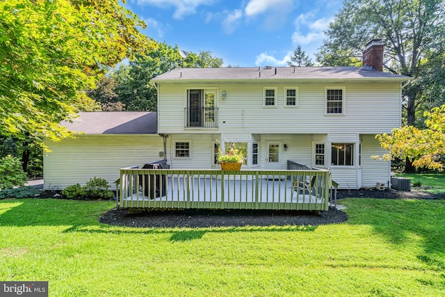 rear view of property with cooling unit, a wooden deck, and a yard