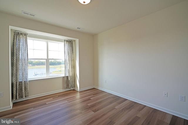 unfurnished room with hardwood / wood-style flooring