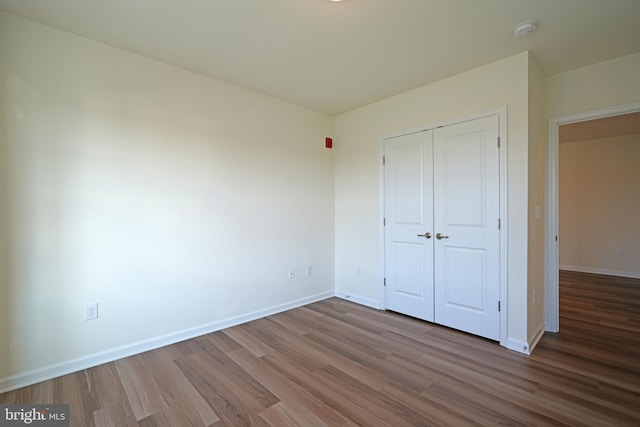 unfurnished bedroom with a closet and wood-type flooring