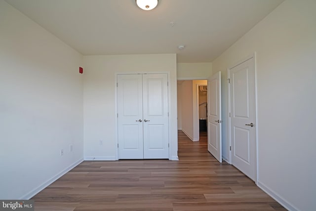 unfurnished bedroom with a closet and hardwood / wood-style flooring