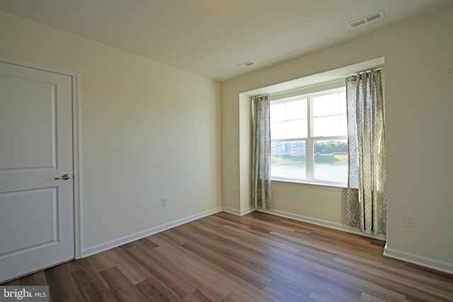 unfurnished room with wood-type flooring