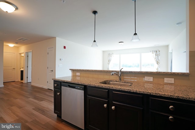 kitchen featuring hardwood / wood-style floors, stainless steel dishwasher, sink, and hanging light fixtures