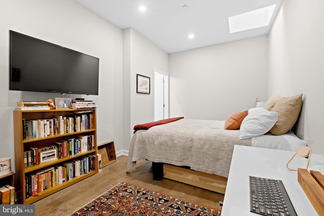 bedroom with wood-type flooring and a skylight