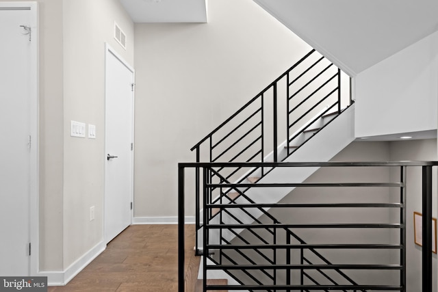 staircase with hardwood / wood-style floors