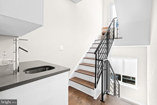 stairs with hardwood / wood-style flooring and sink