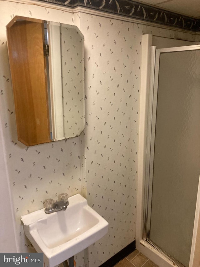 bathroom featuring sink, an enclosed shower, and tile patterned floors