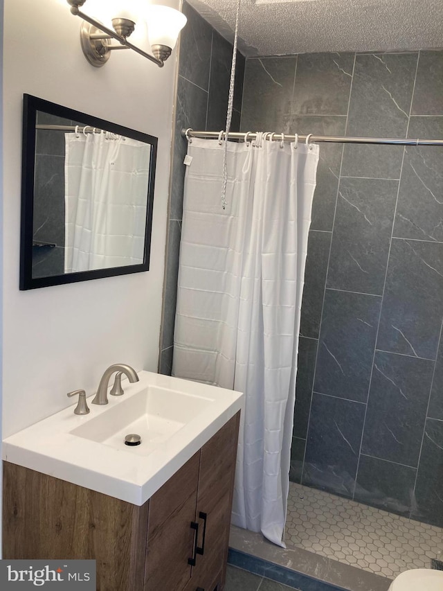 bathroom featuring toilet, a textured ceiling, vanity, and a shower with shower curtain