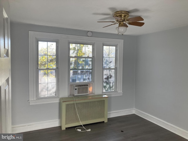 empty room featuring ceiling fan, cooling unit, dark wood-type flooring, and radiator