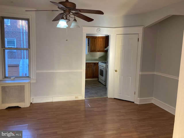 unfurnished room featuring ceiling fan, wood-type flooring, and radiator heating unit