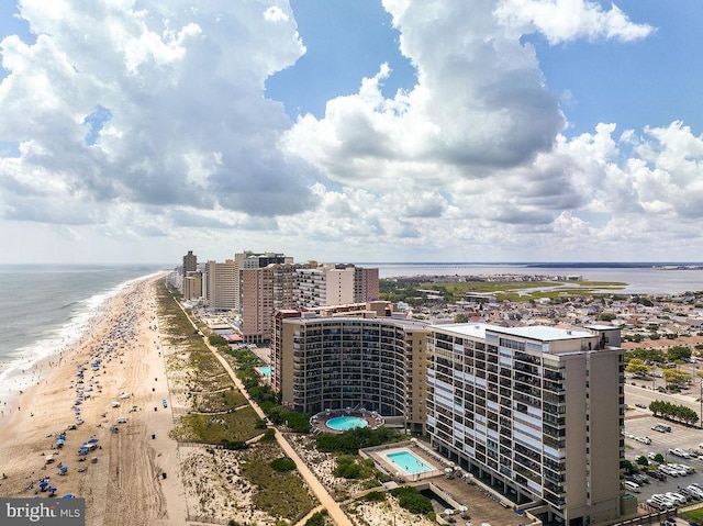 drone / aerial view with a water view, a beach view, and a city view