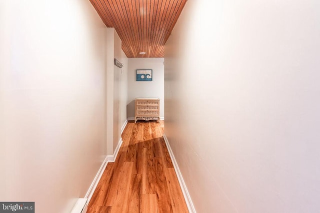 hallway featuring light hardwood / wood-style flooring and wooden ceiling