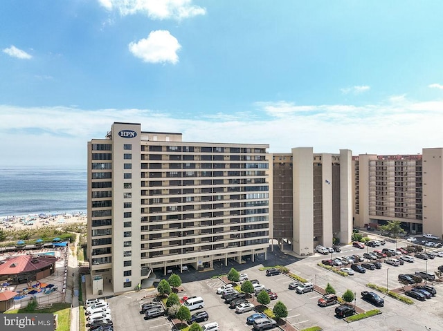 view of building exterior featuring uncovered parking and a water view