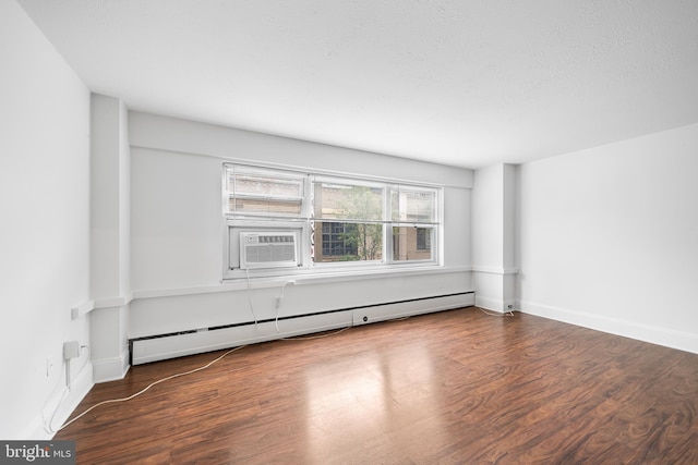 empty room featuring dark wood-type flooring, a baseboard radiator, a textured ceiling, and baseboards