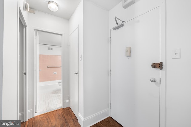 interior space with a shower, visible vents, baseboards, and wood finished floors