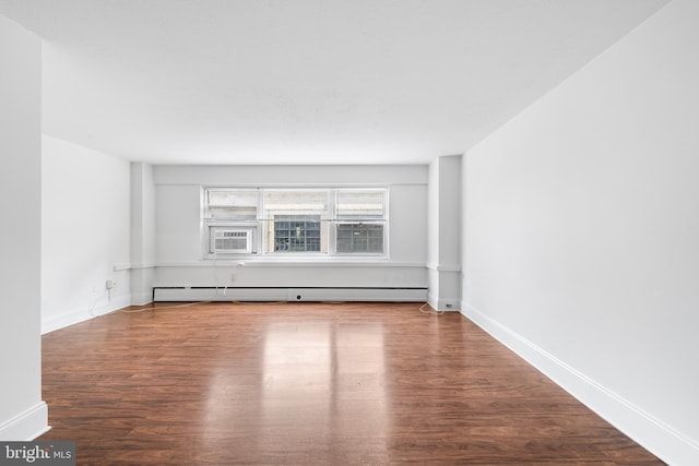 empty room with a baseboard heating unit, cooling unit, baseboards, and wood finished floors