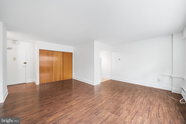 interior space featuring dark wood-type flooring and baseboards