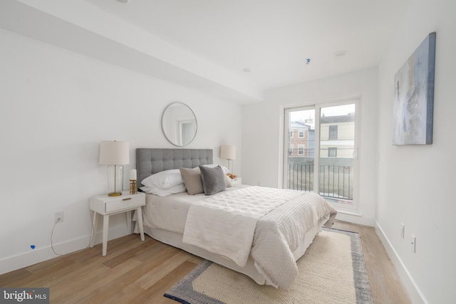 bedroom with light wood-type flooring and access to outside