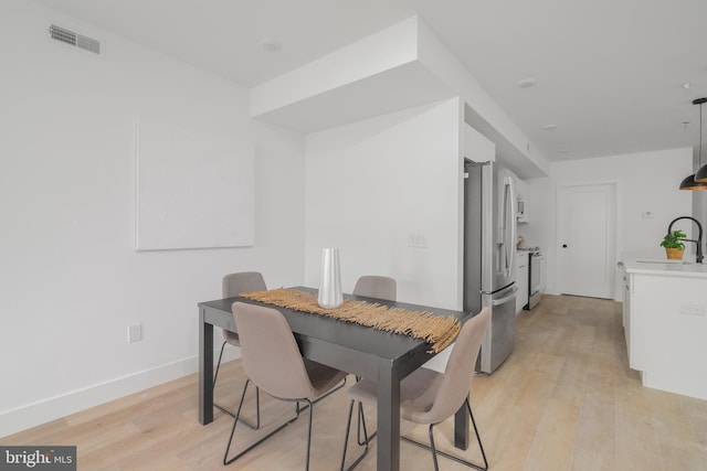 dining room with sink and light wood-type flooring