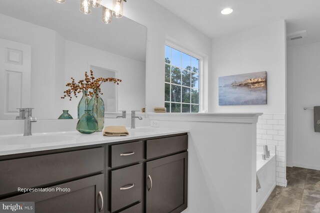 full bath with a garden tub, double vanity, and a sink