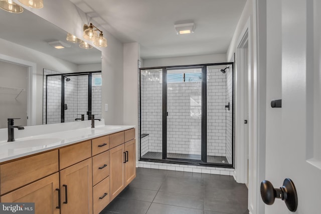 bathroom with double vanity, tile patterned flooring, a sink, and a walk in closet