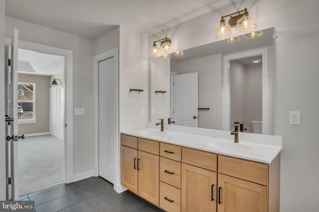 bathroom featuring toilet, double vanity, a closet, and a sink