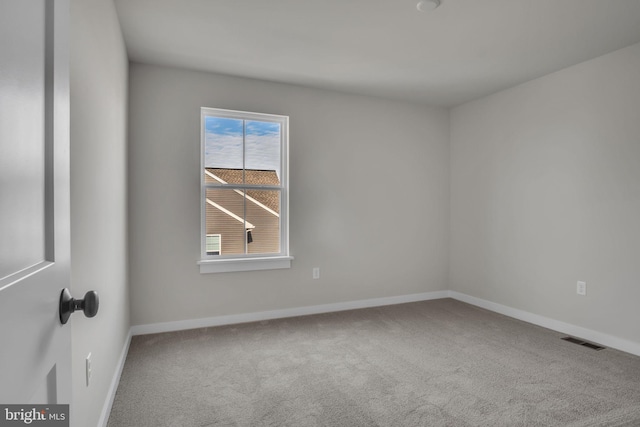 spare room featuring baseboards, visible vents, and carpet flooring