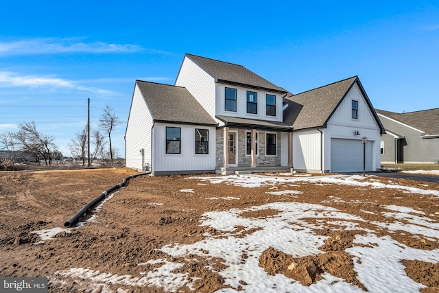 view of front of home with stone siding, roof with shingles, and an attached garage