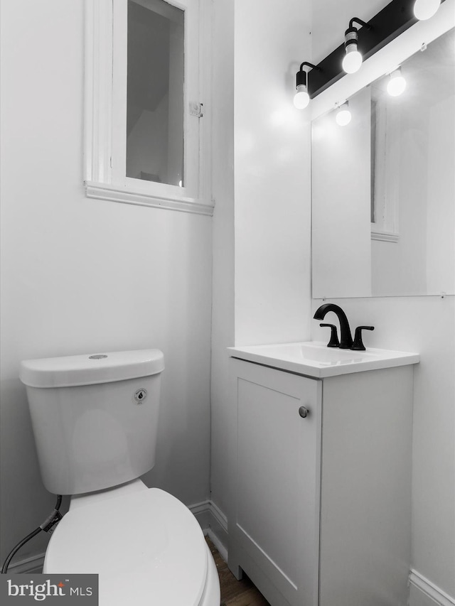 half bathroom with vanity and toilet