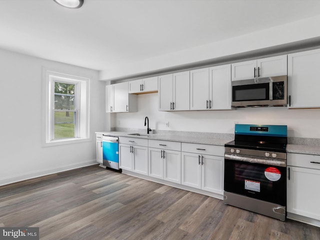 kitchen with white cabinetry, stainless steel appliances, and light countertops