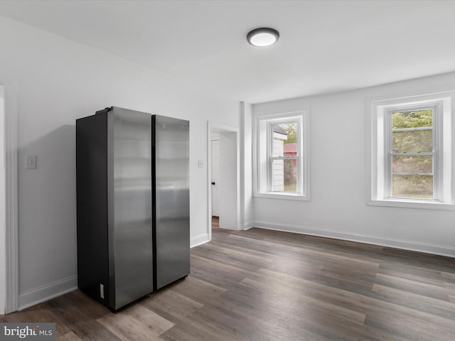 kitchen featuring freestanding refrigerator, dark wood finished floors, and baseboards