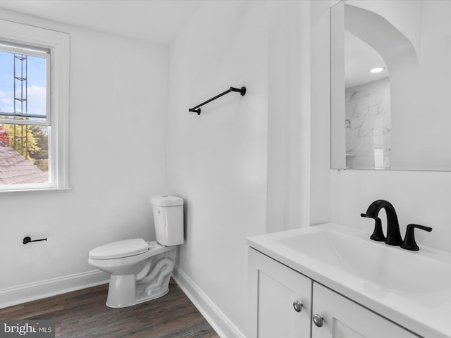 bathroom featuring vanity, wood finished floors, toilet, and baseboards