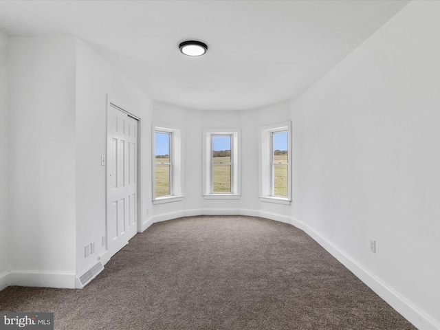 carpeted empty room with baseboards