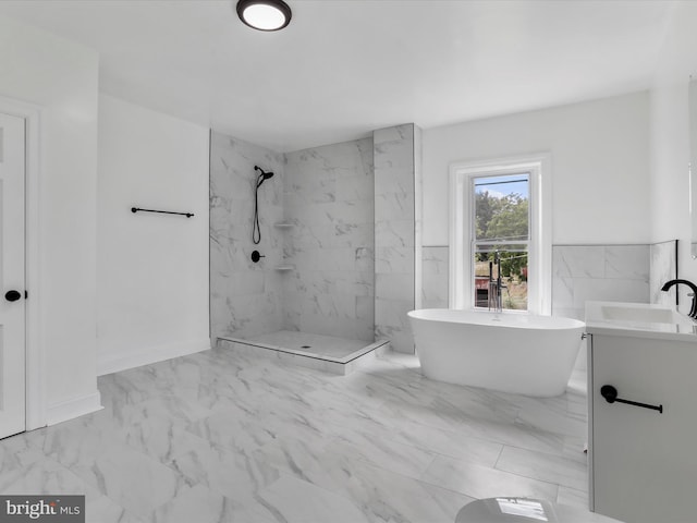 bathroom featuring marble finish floor, a soaking tub, a marble finish shower, and vanity