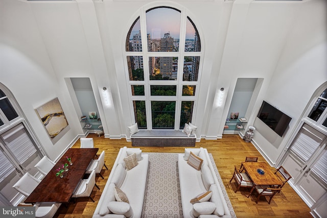 living room featuring a high ceiling and wood-type flooring