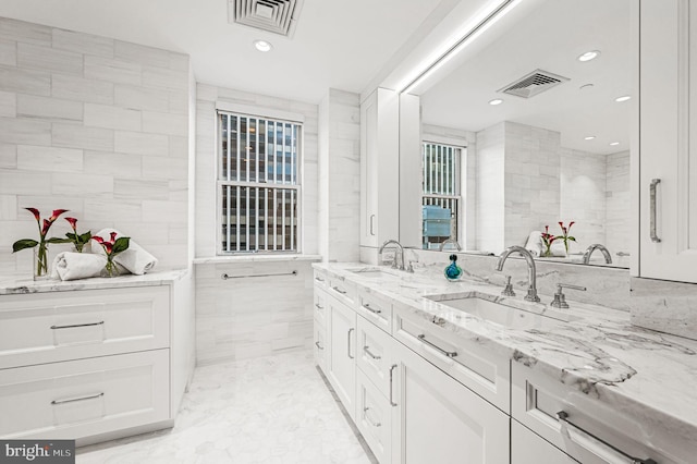 bathroom featuring vanity and tile walls